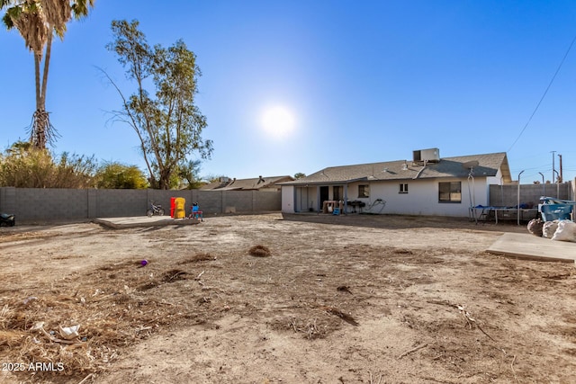 view of yard with a trampoline, cooling unit, a fenced backyard, and a patio