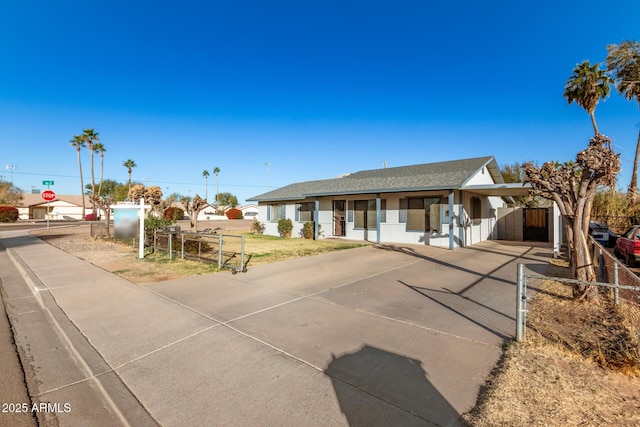 ranch-style home featuring a shingled roof, fence, and a gate