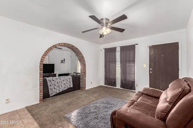 tiled living room with a ceiling fan and baseboards