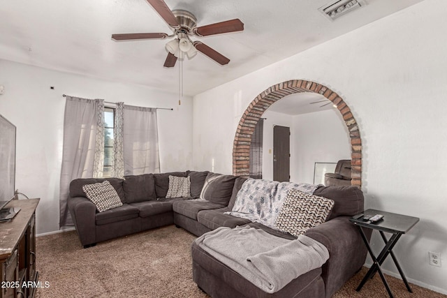 living room featuring baseboards, visible vents, arched walkways, a ceiling fan, and carpet floors