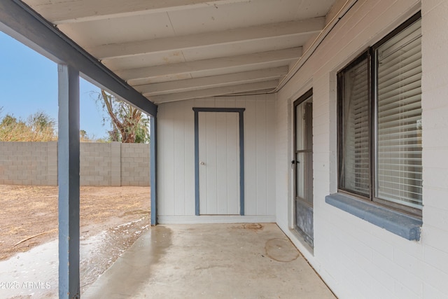 unfurnished sunroom with vaulted ceiling with beams