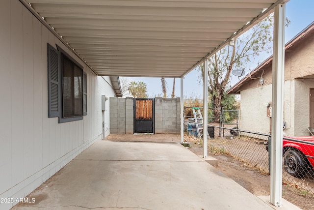 view of patio featuring a carport, a gate, and fence