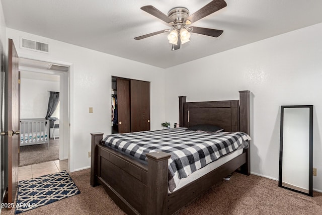 carpeted bedroom featuring a ceiling fan, baseboards, visible vents, and a closet