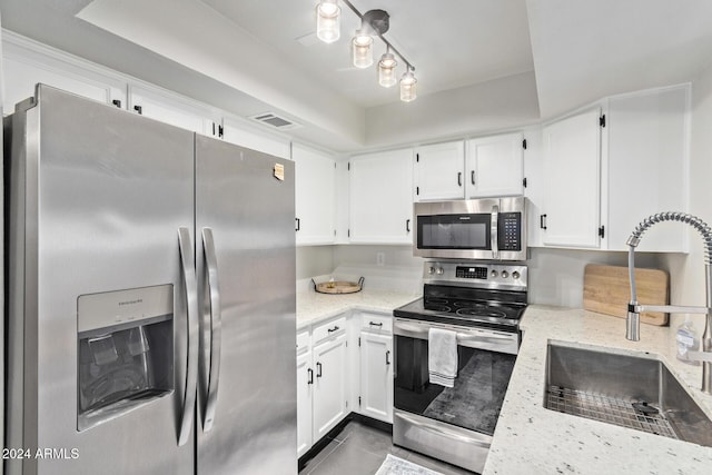 kitchen featuring white cabinetry, light stone counters, sink, and appliances with stainless steel finishes