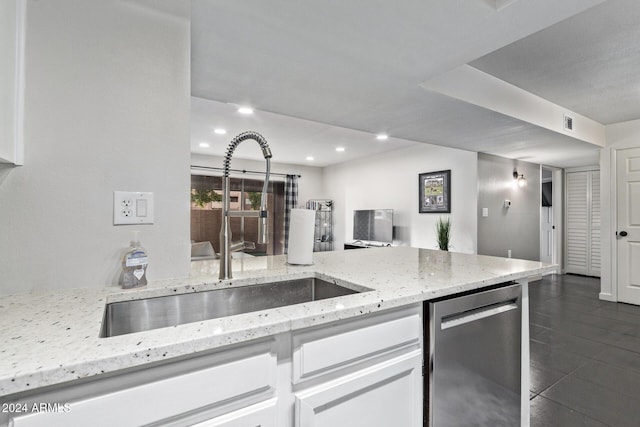 kitchen featuring white cabinets, dishwasher, light stone countertops, and sink