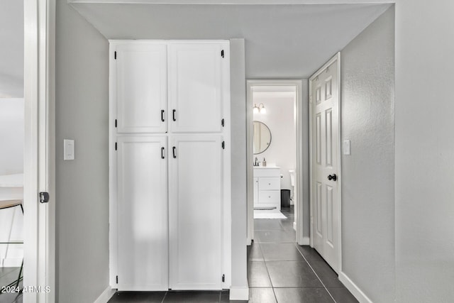 hallway featuring dark tile patterned flooring