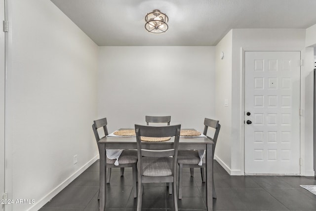 tiled dining area featuring a textured ceiling