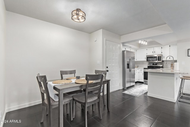 dining area with sink and a textured ceiling