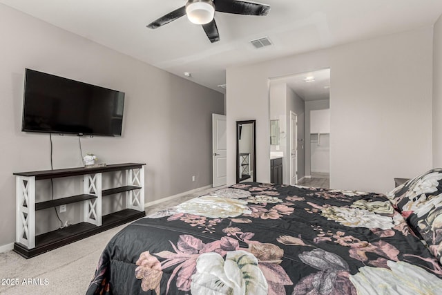 carpeted bedroom featuring baseboards, ensuite bathroom, and a ceiling fan