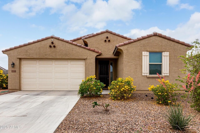 mediterranean / spanish-style home with driveway, an attached garage, stucco siding, and a tile roof