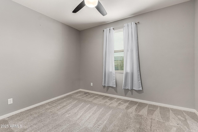 carpeted spare room with ceiling fan and baseboards