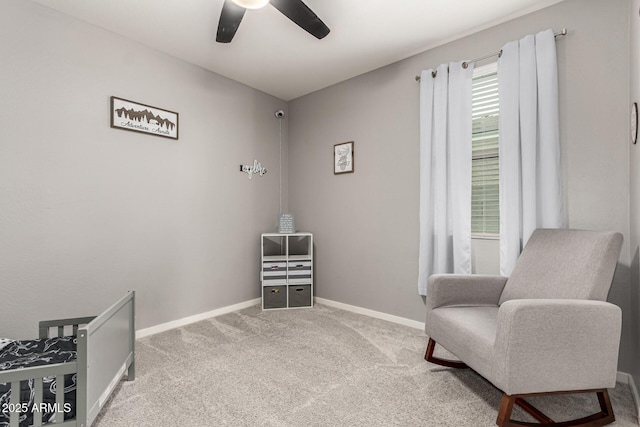 living area with ceiling fan, carpet, and baseboards