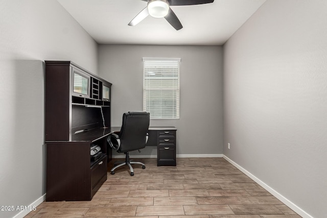 home office with a ceiling fan, light wood finished floors, and baseboards