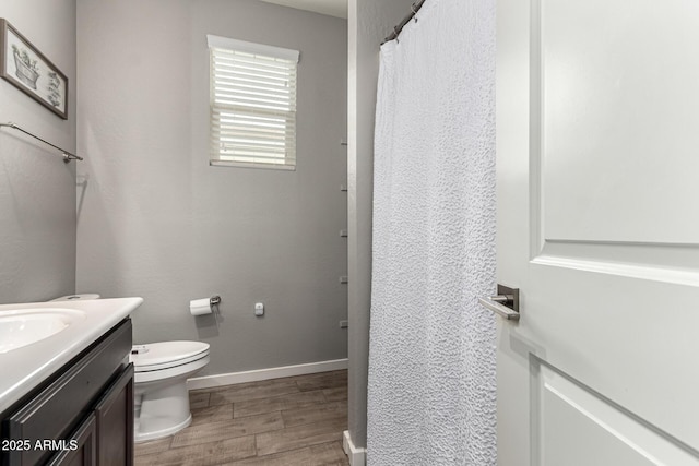 full bath featuring wood finished floors, vanity, toilet, baseboards, and curtained shower