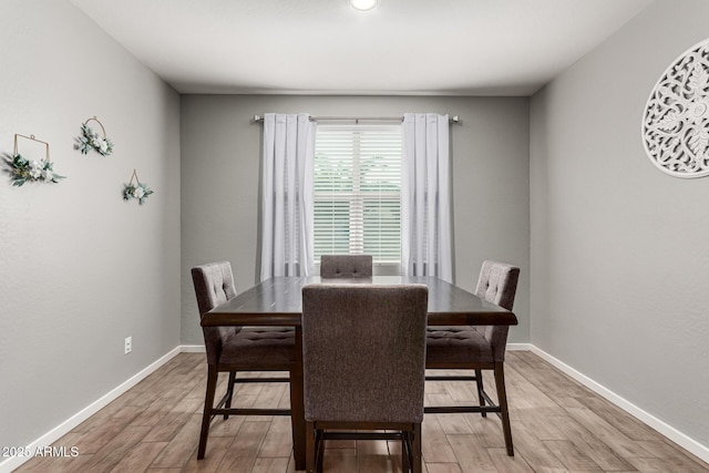 dining room with light wood-style flooring and baseboards