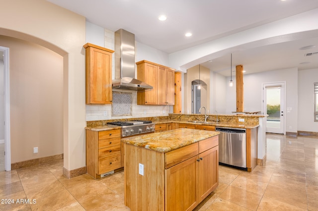 kitchen featuring kitchen peninsula, a kitchen island, wall chimney exhaust hood, stainless steel appliances, and decorative backsplash