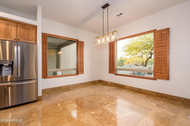 kitchen featuring stainless steel fridge with ice dispenser and decorative light fixtures