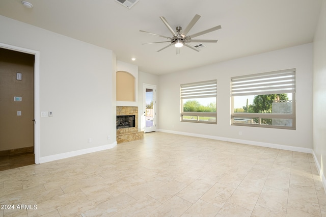 unfurnished living room featuring ceiling fan and a tile fireplace