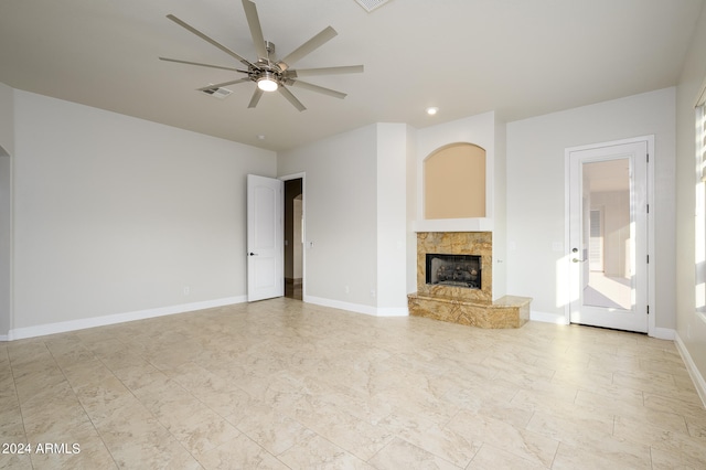 unfurnished living room featuring a high end fireplace and ceiling fan