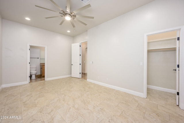 unfurnished bedroom with a spacious closet, ensuite bath, ceiling fan, and a closet