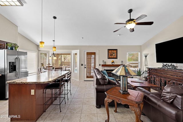 4131 E Cascalote Dr, Cave Creek, AZ 85331 - living area with lofted ceiling, ceiling fan, plenty of natural light, a fireplace, and light tile patterned floors