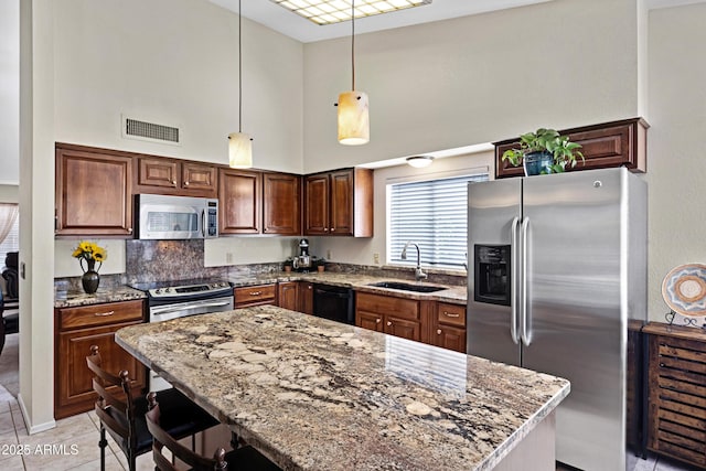 4131 E Cascalote Dr, Cave Creek, AZ 85331 - kitchen with stainless steel appliances, a towering ceiling, stone countertops, a breakfast bar, and pendant lighting