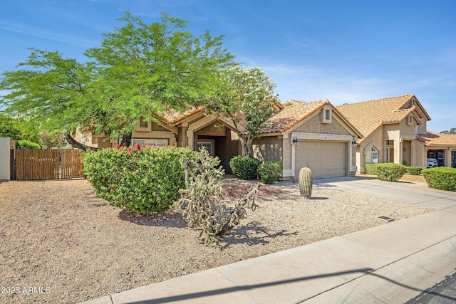 4131 E Cascalote Dr, Cave Creek, AZ 85331 - obstructed view of property featuring an attached garage, a gate, stucco siding, concrete driveway, and a tiled roof