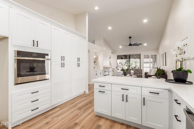 kitchen with white cabinetry, ceiling fan, stainless steel appliances, and lofted ceiling