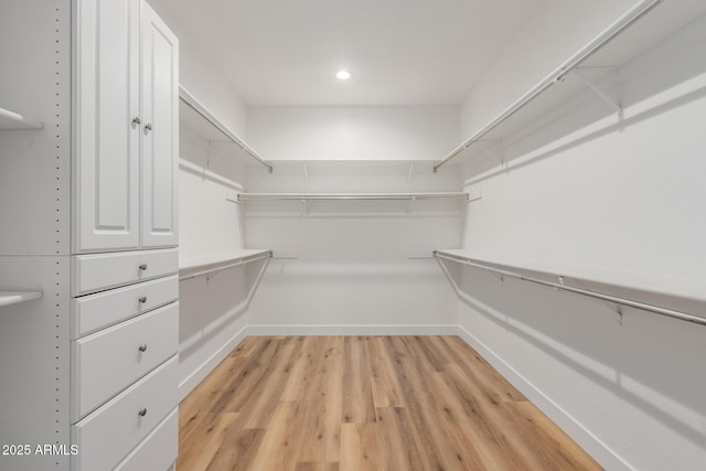 walk in closet with light hardwood / wood-style floors