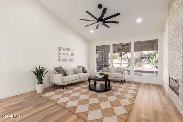 living room with high vaulted ceiling and light wood-type flooring