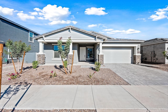 22652 E Lords Way, Queen Creek, AZ 85142 - view of front of home featuring an attached garage, stucco siding, decorative driveway, a porch, and stone siding