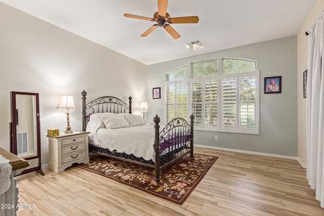 bedroom with ceiling fan, light hardwood / wood-style flooring, and lofted ceiling