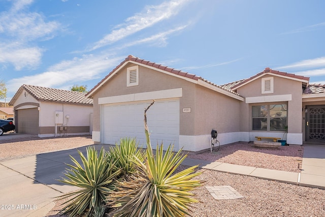 mediterranean / spanish-style home featuring a garage, a tile roof, concrete driveway, and stucco siding