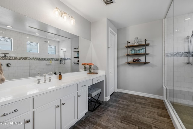 bathroom featuring a tile shower and vanity