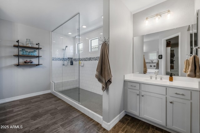 bathroom featuring tiled shower and vanity