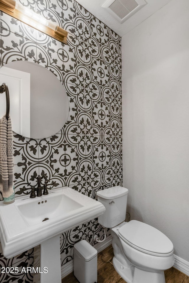 bathroom featuring hardwood / wood-style flooring, toilet, and sink