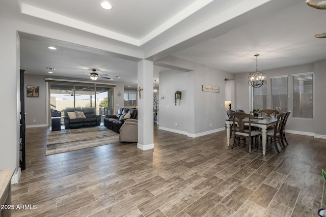 dining space featuring ceiling fan with notable chandelier