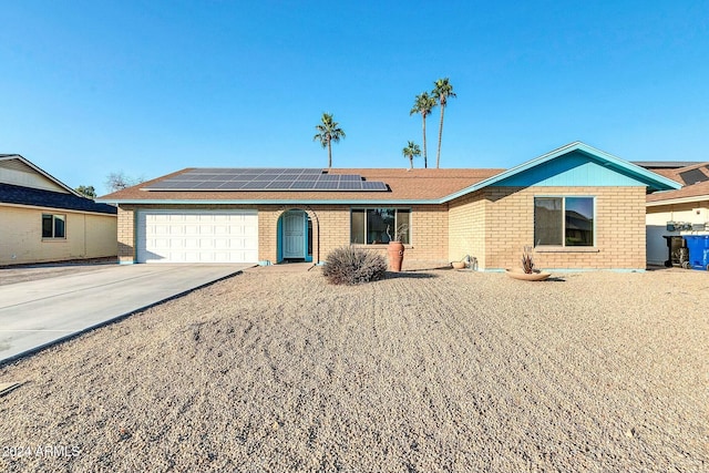 ranch-style home featuring solar panels and a garage