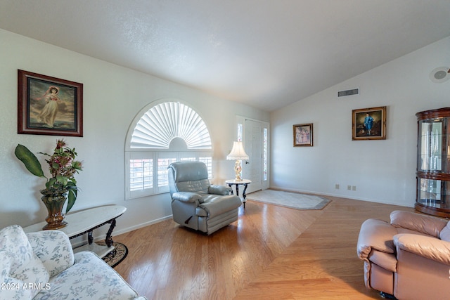 living room with lofted ceiling and light hardwood / wood-style flooring