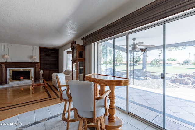 tiled dining room featuring a textured ceiling, ceiling fan, and built in features