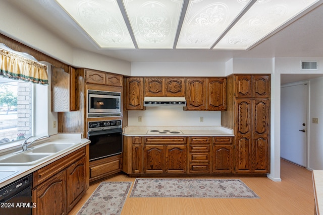 kitchen with black appliances, light hardwood / wood-style floors, and sink