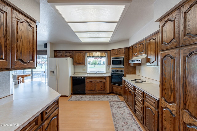 kitchen with a textured ceiling, sink, and black appliances