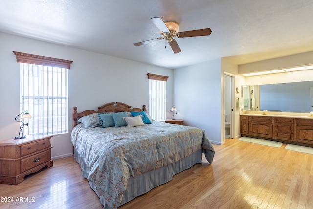 bedroom featuring light hardwood / wood-style flooring, ensuite bath, and multiple windows