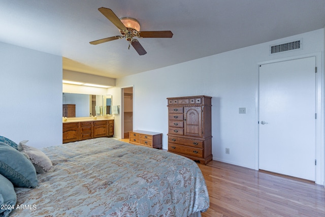 bedroom with ceiling fan, light hardwood / wood-style flooring, and ensuite bathroom