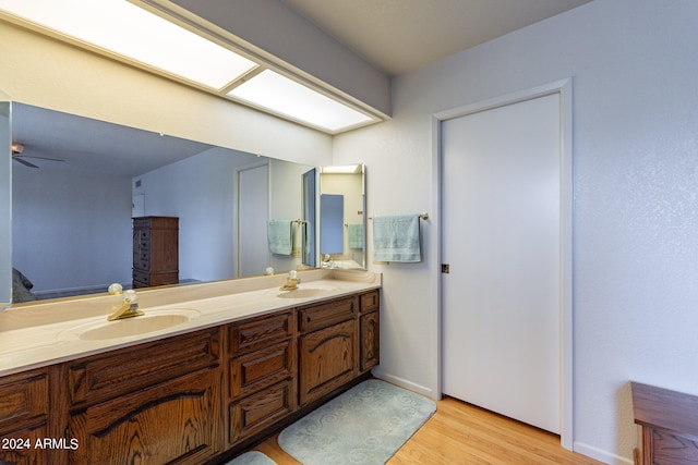 bathroom with hardwood / wood-style floors, ceiling fan, and vanity