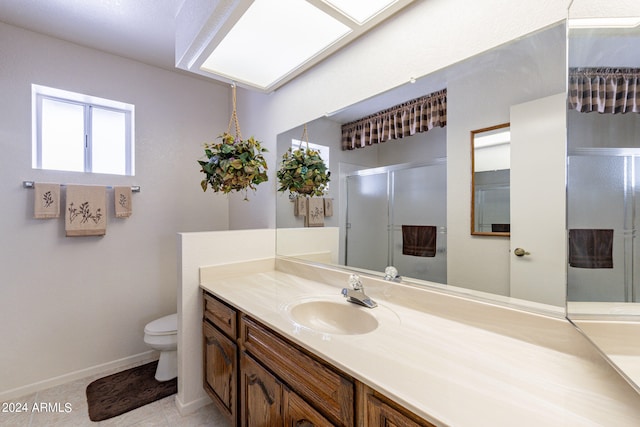 bathroom with tile patterned flooring, an enclosed shower, vanity, and toilet