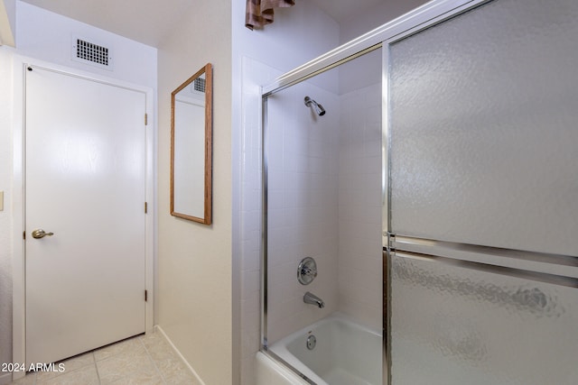 bathroom featuring tile patterned flooring and combined bath / shower with glass door