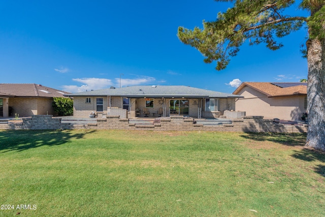 rear view of house featuring a lawn and a patio area