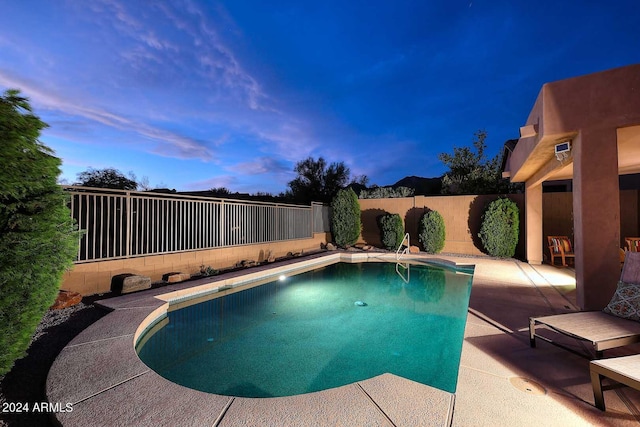 pool at dusk featuring a patio area