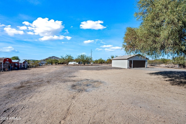 view of yard with a mountain view, a garage, and an outbuilding